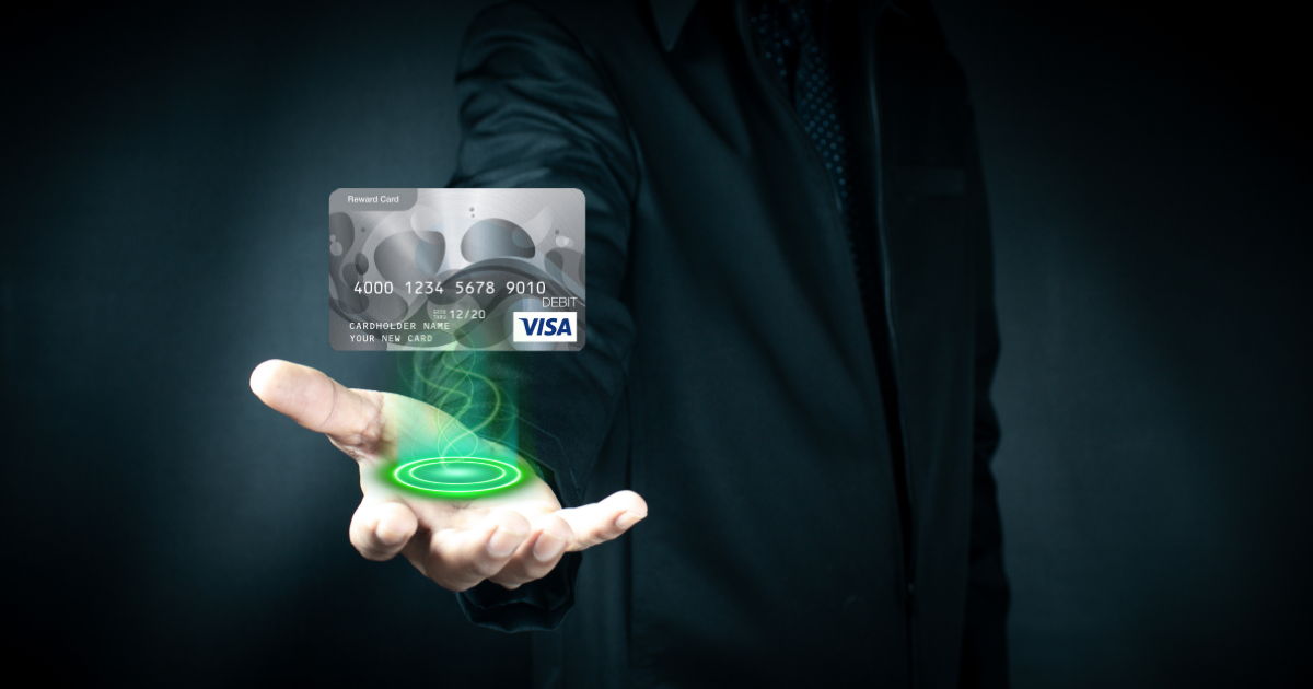 A Visa Prepaid Gift Card hovers in the palm of an outstretched had, bathed in green light.